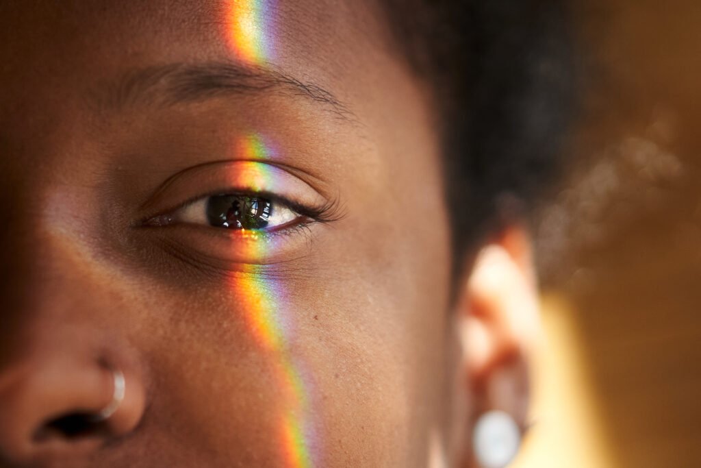 close up photo of multi coloured light falling on human eye.