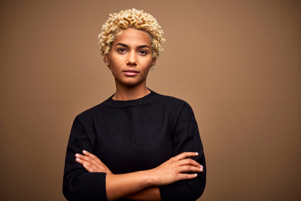 confident young female afro owner against brown background