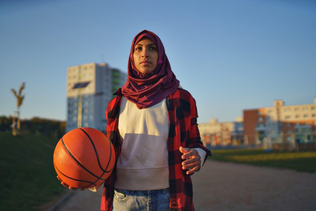 muslim young woman outdoors in the city, with basketball.